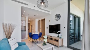 Un salon moderne comprenant un canapé, une table basse, un téléviseur et un coin repas.