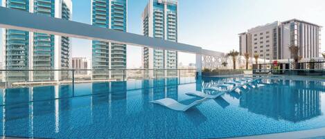 Piscine extérieure, parasols de plage, chaises longues
