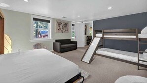 Une chambre avec des lits superposés, un canapé et une fenêtre donnant sur un beau paysage.