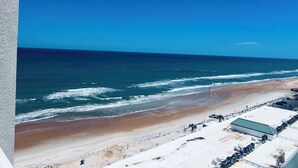 Une vue sur la plage avec un bâtiment et un parking.