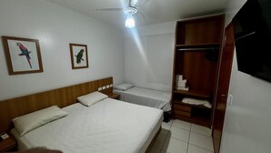 A hotel room with a bed, a nightstand, a wardrobe, and two framed bird pictures on the wall. - Golden Dolphin Grand Hotel (Caldas Novas)