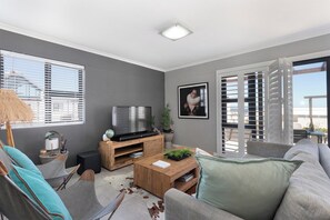 A living room with a television, a coffee table, and a sofa.
