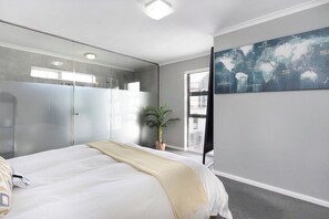 A bedroom with a bed, a large mirror, a potted plant, and a world map on the wall.