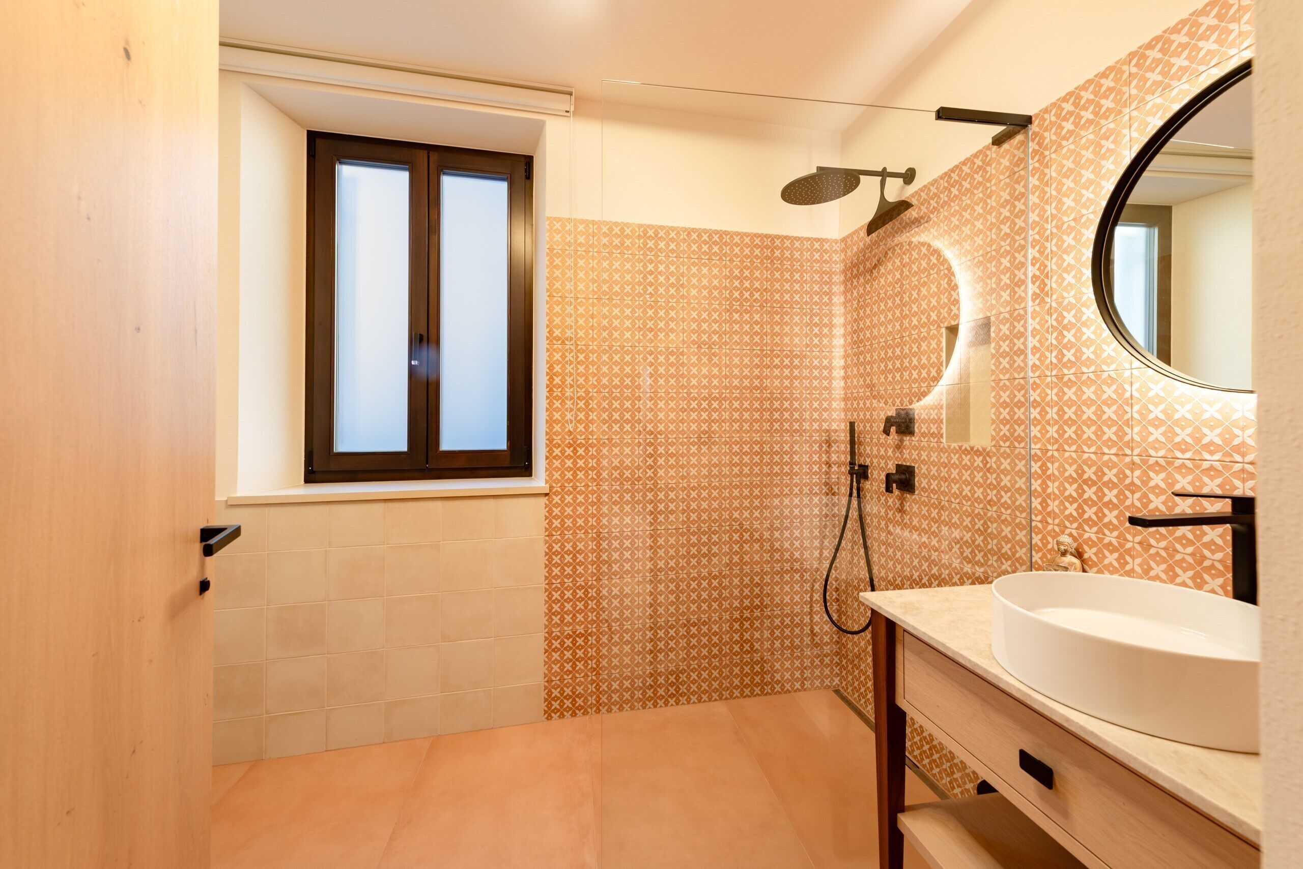 Une salle de bain avec une fenêtre, une douche et un lavabo.