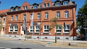 A red brick building with multiple windows and a sign for a wellness hotel.