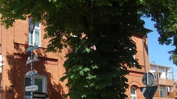 A historic building with multiple signs, including 'BIEGARTEN' and 'ZUR KRONE'.