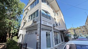 Ein mehrstöckiges Gebäude mit Schildern für 'Boutique Museum' und 'Hotel Tirana'.