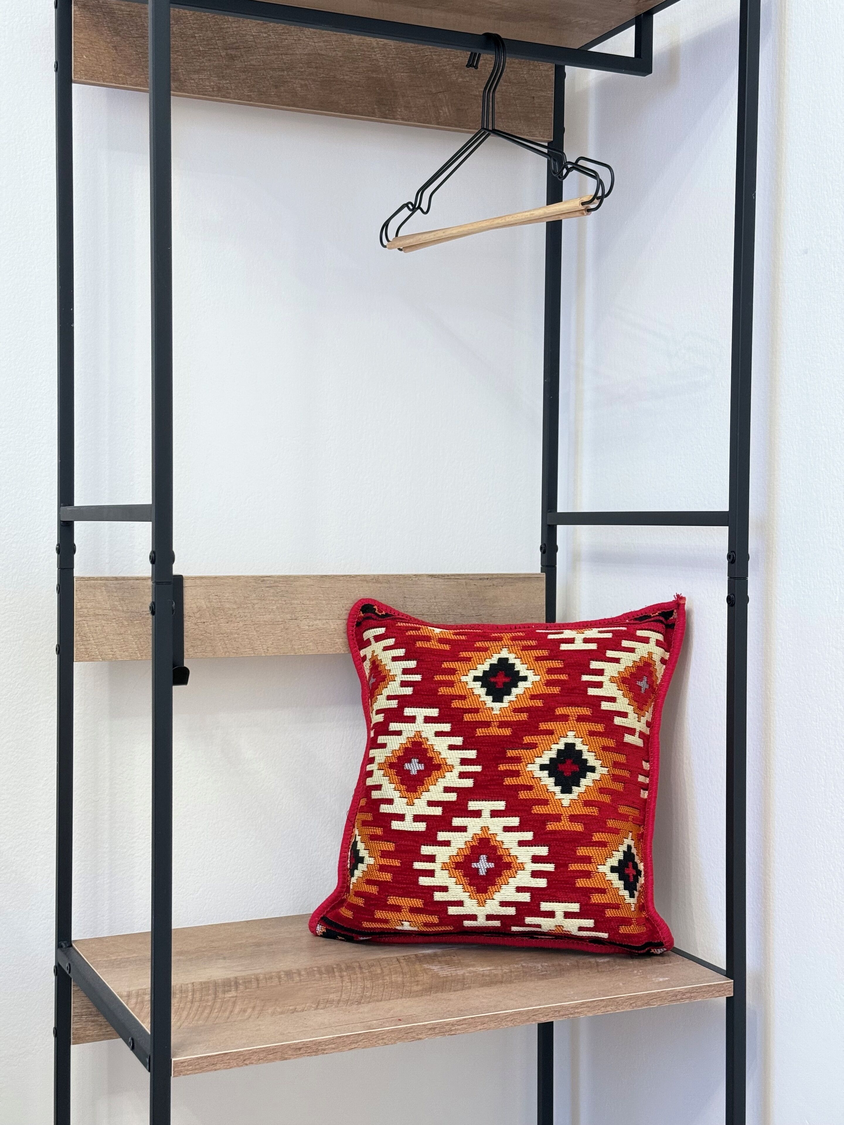 A corner of a room with a wooden shelf and a hanging wooden hanger.