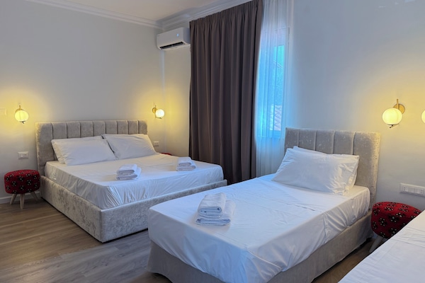 Neljän hengen standard-huone, kaupunkinäköala | Työpöytä, kannettavalle tietokoneelle sopiva työtila, pimennysverhot