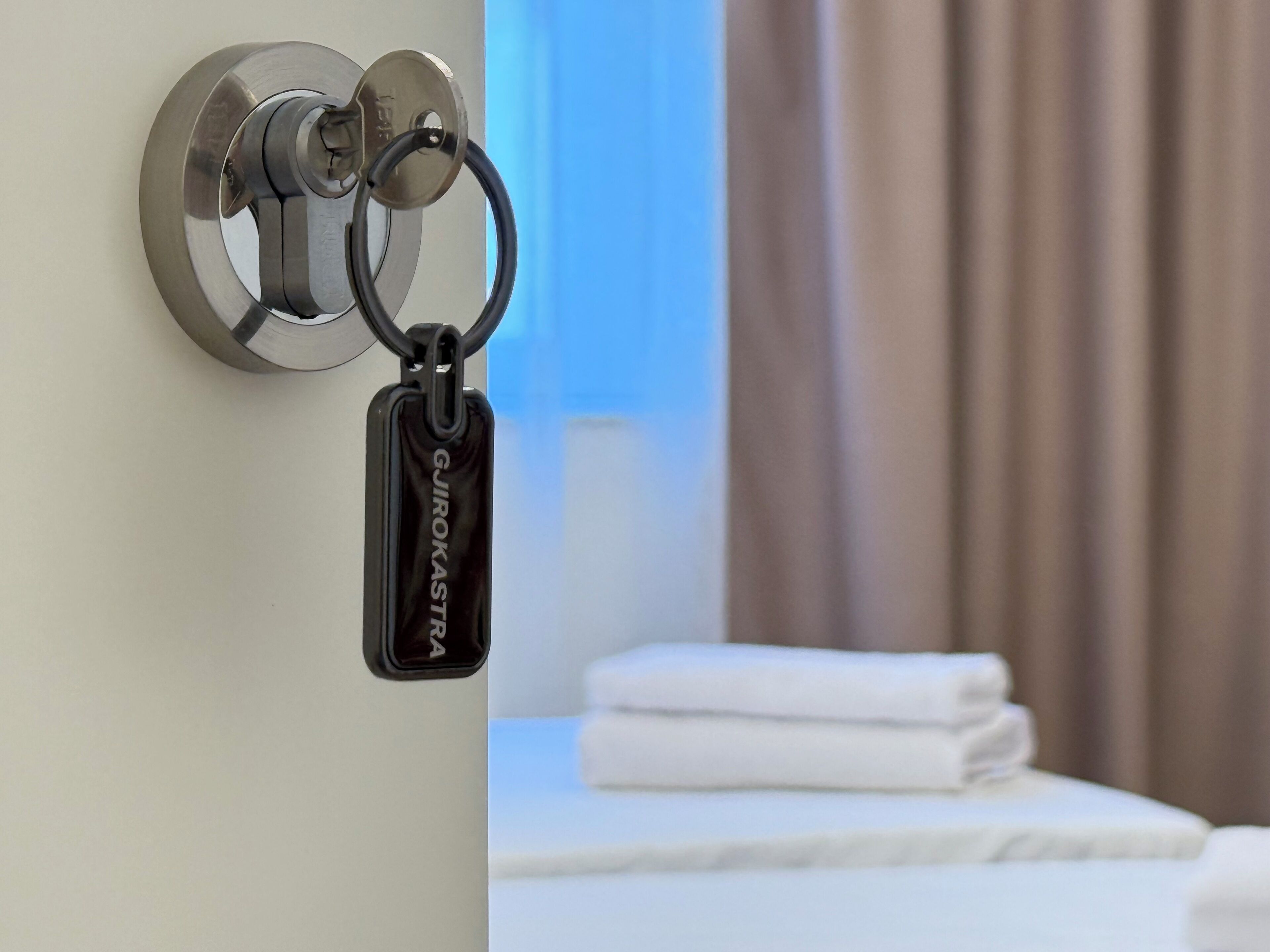 A hotel room with a door lock and a keycard holder.