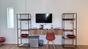Ein modernes Zimmer mit einem Holztisch, einem Fernseher und zwei Metallregalen.