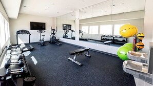A gym with exercise equipment, a bench, dumbbells, a treadmill, and a mirror. - Heartland Flats  (Alliance)