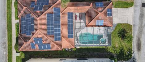 A residential area with multiple houses, each featuring solar panels on the roofs.