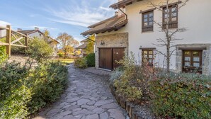 Un sendero de piedra que lleva a una casa con puerta y ventanas de madera.
