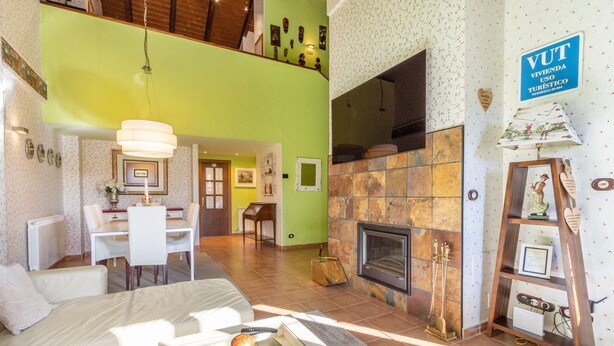 Un amplio espacio habitable con chimenea, una mesa de comedor y un sofá.