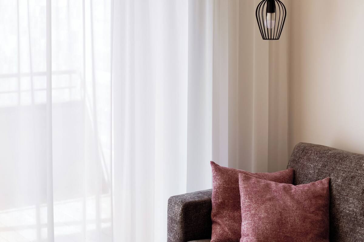 A modern living room with a sofa, a wooden coffee table, and three pendant lights.