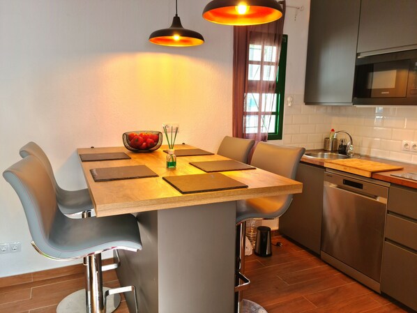 A modern kitchen with a central island, stainless steel appliances, and pendant lighting. - Quaint 1-bedroom bungalow in Costa Calma. Casa Viola (Costa Calma)
