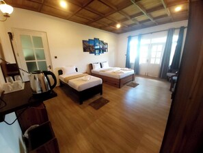 A room with two beds, wooden flooring, a ceiling with exposed beams, a wall-mounted artwork, and a window with curtains. - The Hill Cliff Nuwara Eliya (Nuwara eliya)