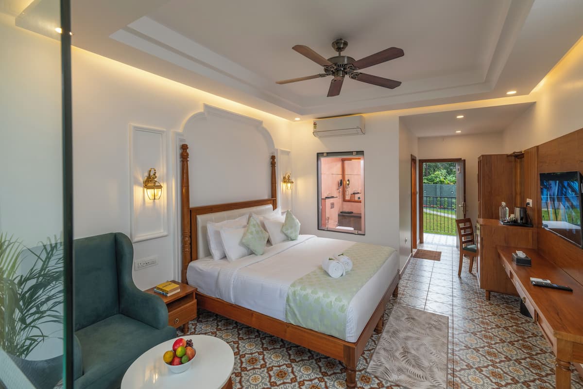 A well-lit bedroom with a bed, bedside table, and a chair.
