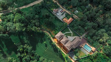 Vista aérea de una propiedad residencial con una casa grande, piscina y jardín cuidado.