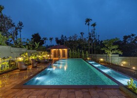 Una piscina al aire libre, sillones reclinables de piscina