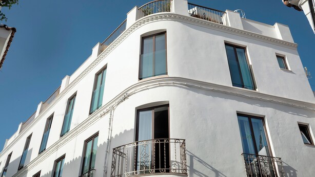 Un bâtiment blanc doté de nombreuses fenêtres et de balcons.