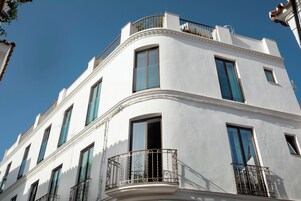 Un bâtiment blanc doté de nombreuses fenêtres et de balcons.