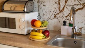 A kitchen with a white microwave, a toaster, and a fruit display. - Comfortable Holiday Homes in Mielno (Mielno)