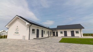 Un bâtiment moderne doté d’un toit plat et d’un espace d’entrée pavé.