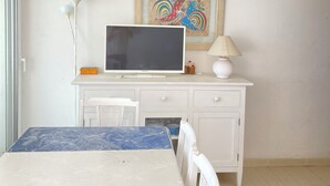 A bedroom with a bed, a desk with a computer, a lamp, and a framed picture on the wall. - Calafell beachfront apartment with swimming pool (Calafell)