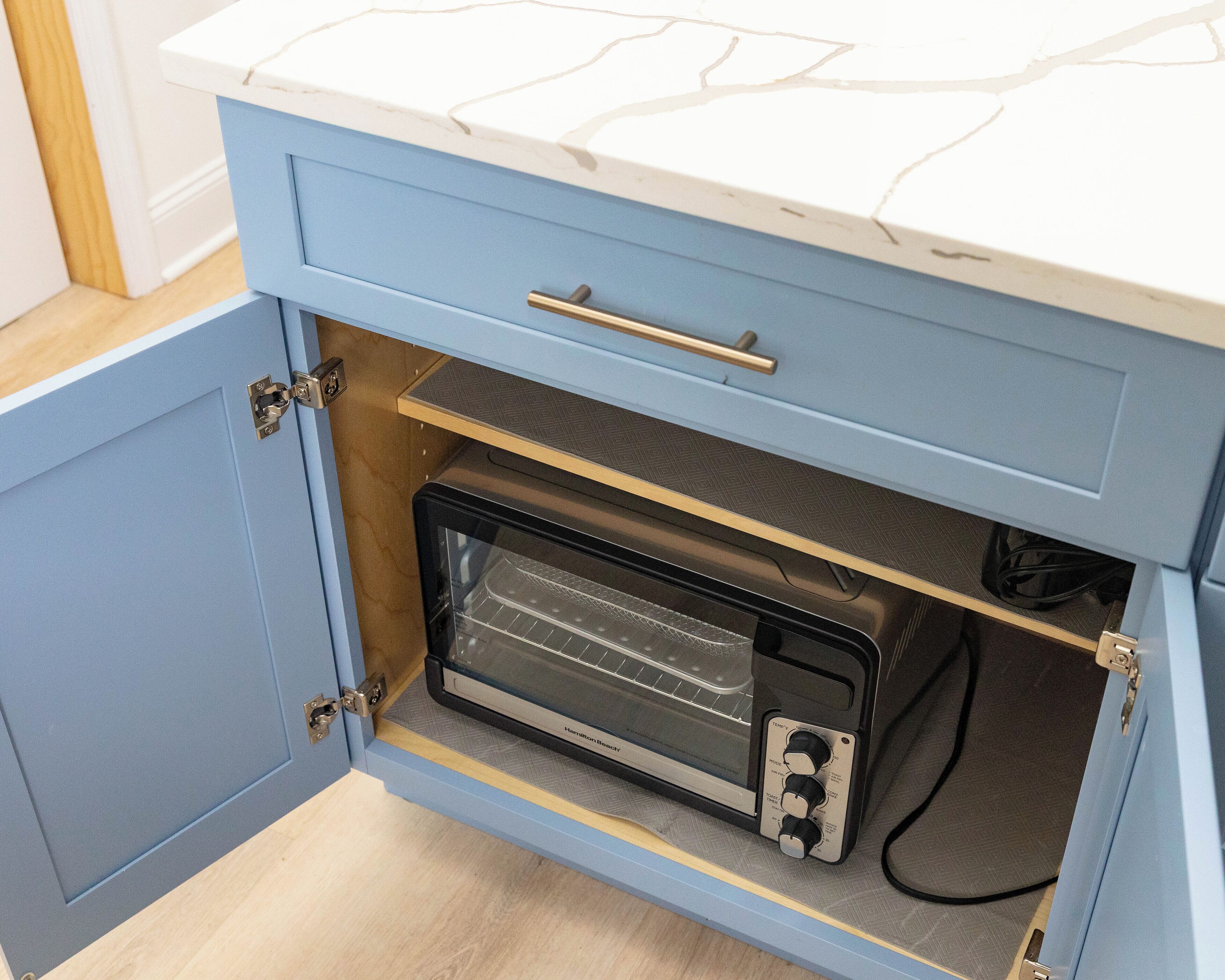 Una cocina con horno empotrado y un cajón con tirador.