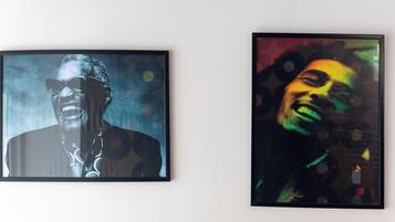 Two framed portraits of a person with a blurred face, one in black and white and the other in color, displayed on a wall.