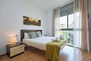 Une chambre à coucher moderne avec un lit, une table de chevet et une fenêtre avec des rideaux.