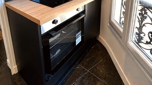 A compact kitchen with a built-in stove, oven, and a small countertop.