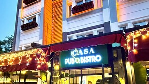 Un edificio con un letrero de 'CASA PUB & BISTRO', un letrero de 'HOTEL' y un letrero de 'LARA ANTALYA'.