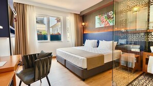 Habitación de hotel moderna con una cama grande, un escritorio y una silla.