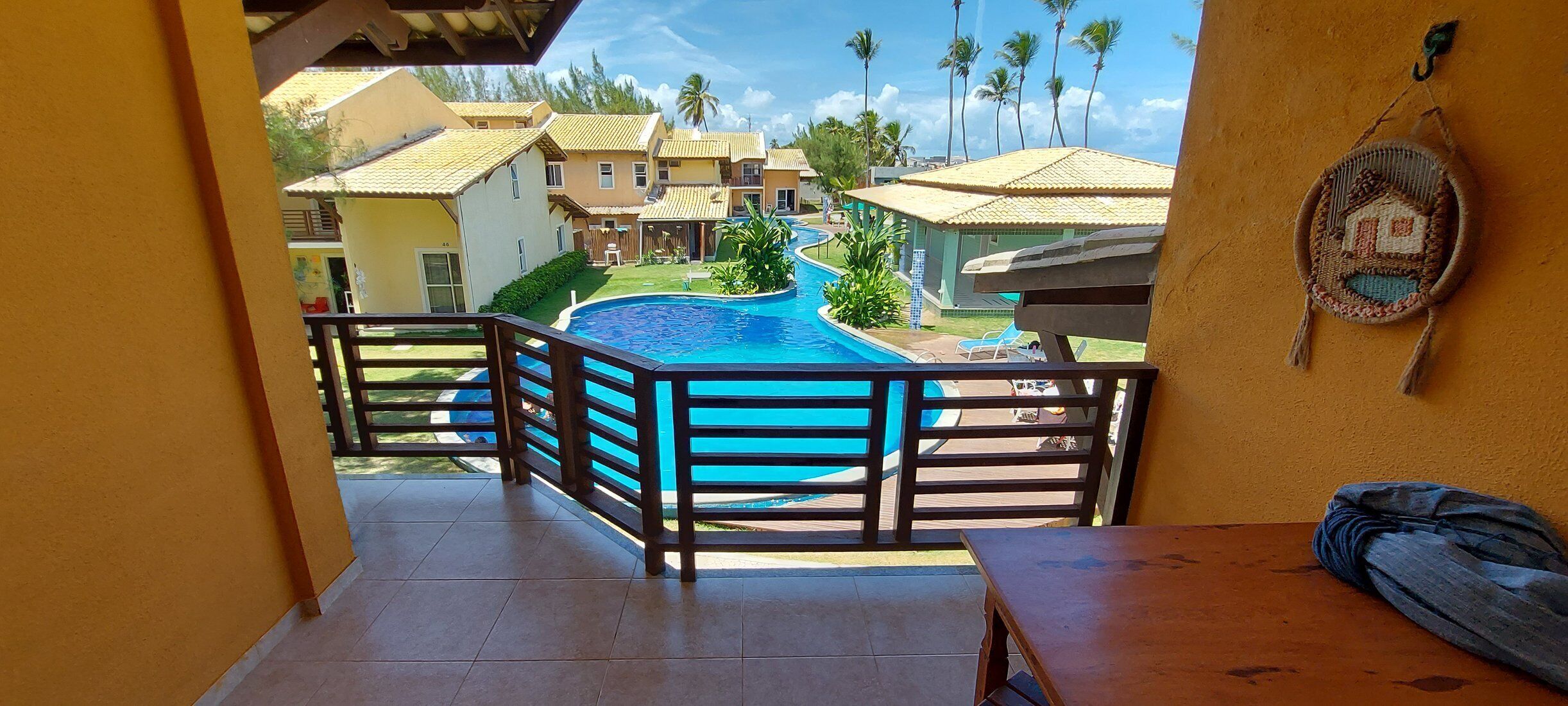 A balcony with a view of a swimming pool and resort buildings.