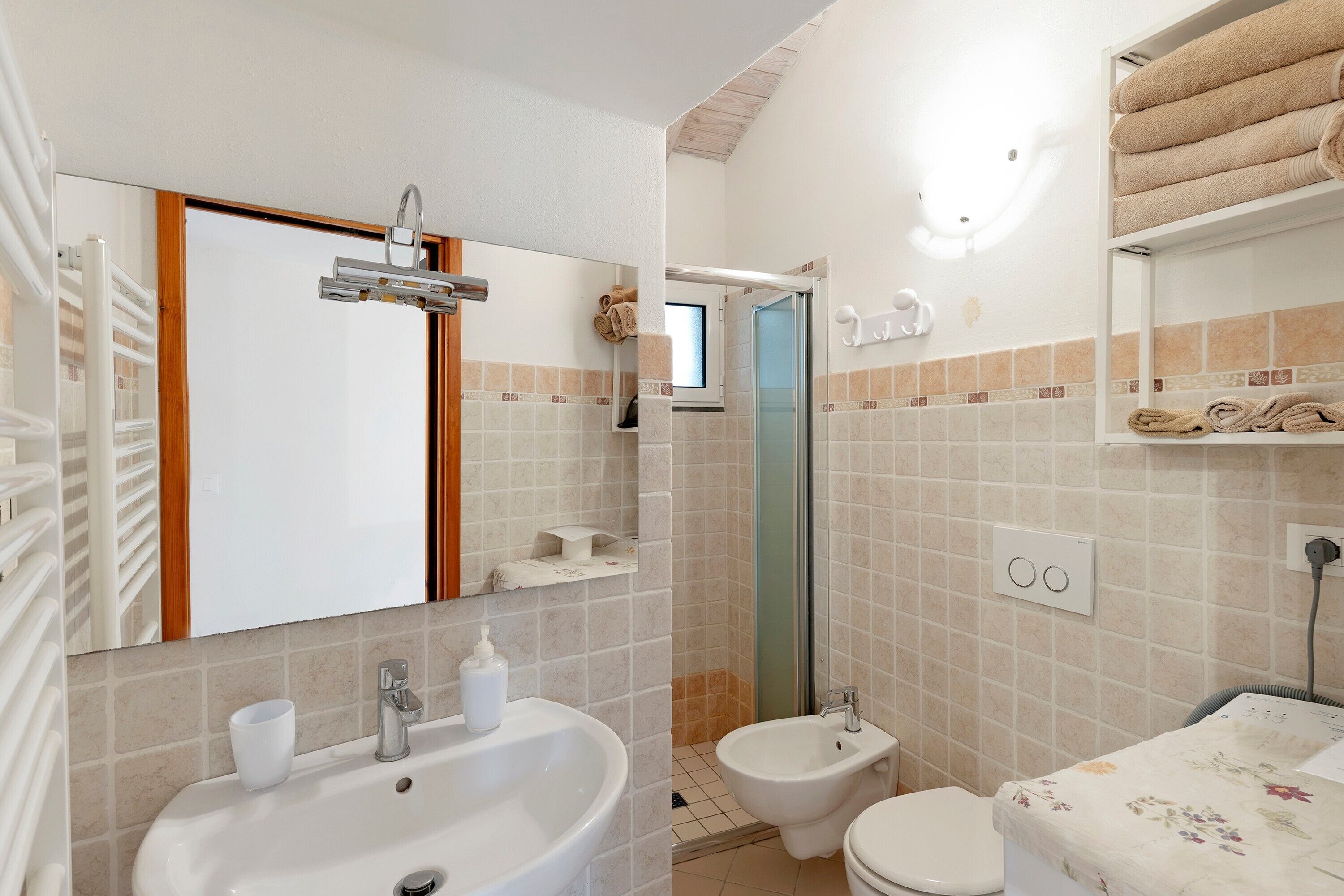 Une salle de bain équipée d’un lavabo, d’un bidet, de toilettes et d’un miroir.