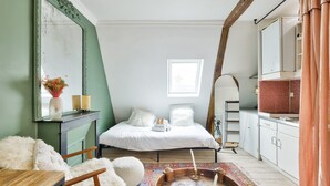 Une chambre à coucher comprenant un lit, une coiffeuse avec un miroir, une commode et un grand miroir mural.