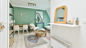 Une pièce comprenant un bureau, deux chaises, un miroir et un radiateur.