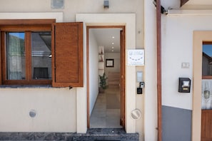 Una entrada de edificio con una puerta de madera, un letrero que indica 'Le 5 Perle' y el número 5 en la pared.