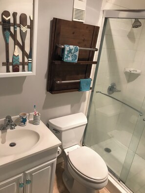 Ein Badezimmer mit Toilette, Waschbecken und Duschkabine aus Glas.