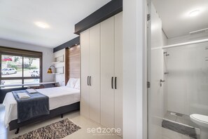Una camera da letto moderna con letto, armadio e zona doccia.