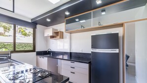 Une cuisine moderne dotée d’une cuisinière à gaz, de plans de travail noirs et d’armoires blanches.
