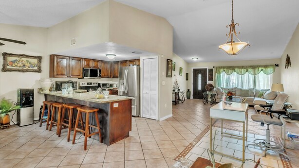 A spacious living area with a kitchen, a dining area, and a seating space with a sofa and chairs. - beautiful and safe golf neighborhood.
 10 minute from downtown and the beach (St. Petersburg)
