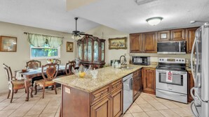 A kitchen with wooden cabinets, a granite countertop, a dishwasher, a stove, and a microwave. - beautiful and safe golf neighborhood.
 10 minute from downtown and the beach (St. Petersburg)