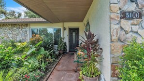 A house with a stone exterior, a number 5100 sign, and a variety of potted plants in front. - beautiful and safe golf neighborhood.
 10 minute from downtown and the beach (St. Petersburg)