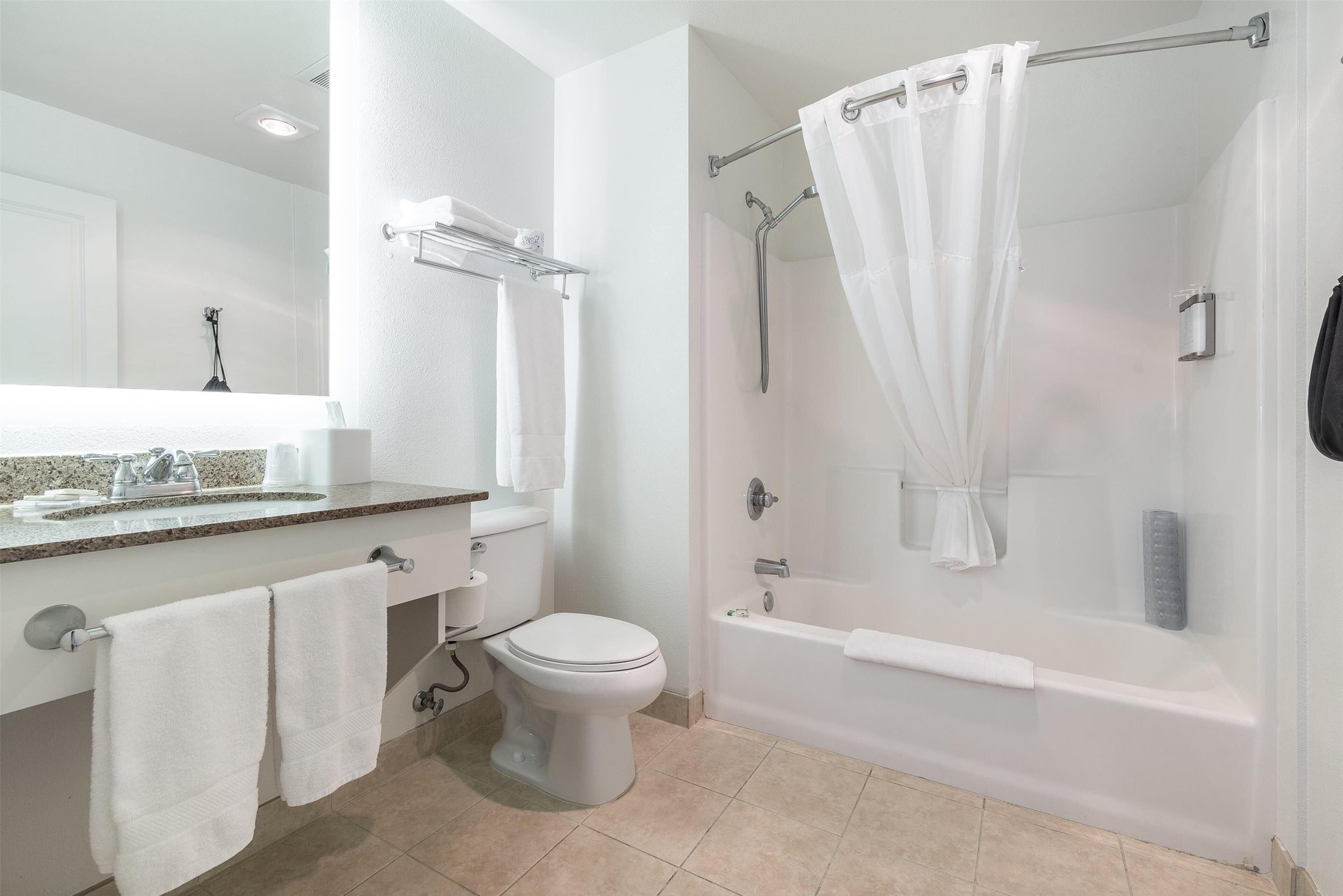 A modern bathroom with a toilet, sink, and bathtub.