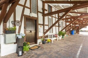 A traditional building with exposed wooden beams, a wooden door, and potted plants on the ground. - Apartment 'Beti' with Private Garden and Wi-Fi (Korbach)