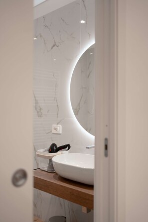 Een douche, een haardroger, een bidet, handdoeken